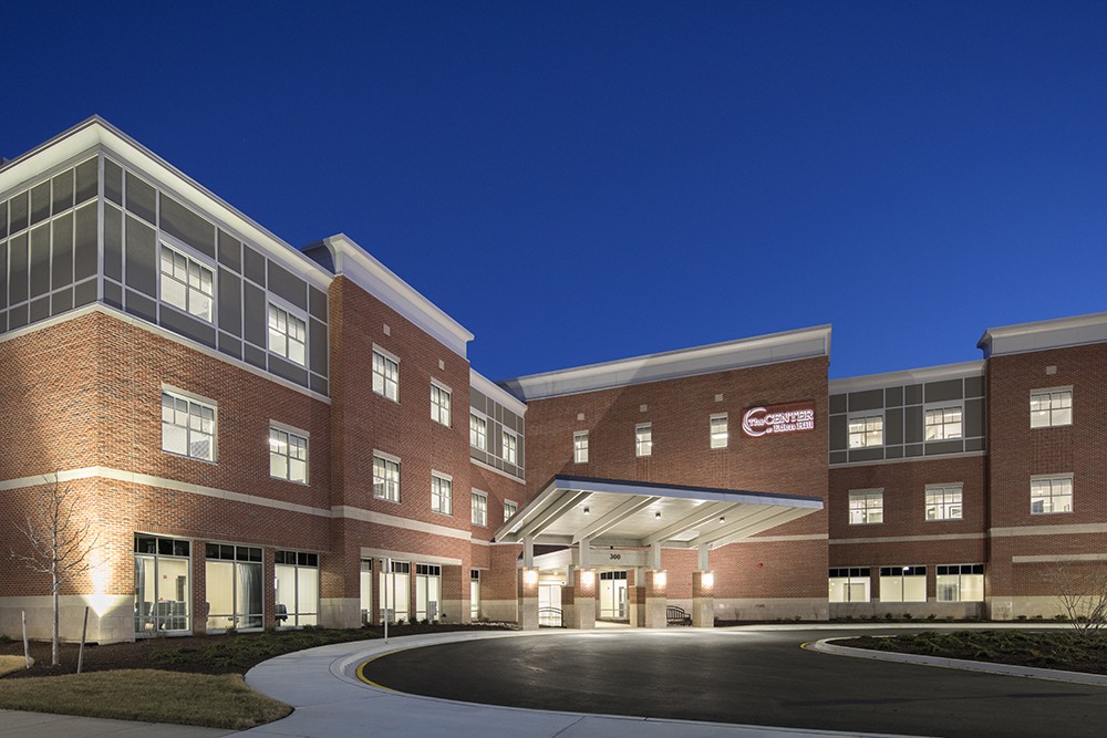 A well-lit hospital building at night, showcasing its modern architectural design.