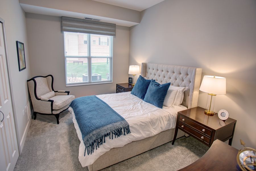 A cozy bedroom interior with a neatly made bed and elegant decor.