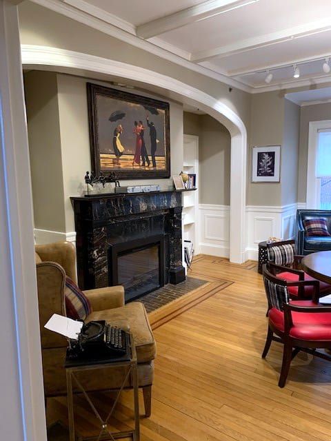 A cozy living room featuring a fireplace, surrounded by elegant artwork and furniture.