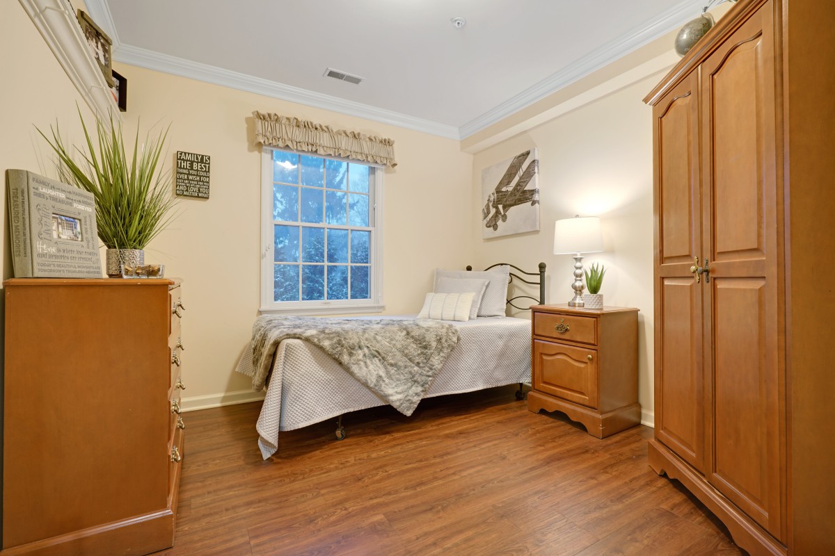 A cozy bedroom with wooden furniture and a bed next to a window.