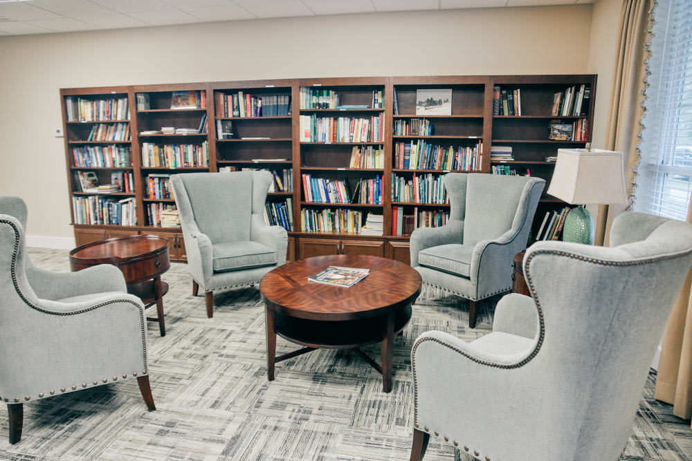 A cozy library reading area with armchairs and bookshelves.