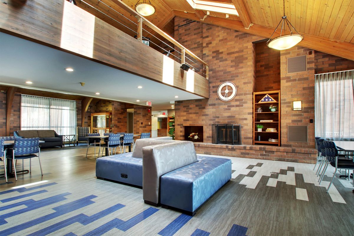 A modern lobby with stylish furniture and a large fireplace.