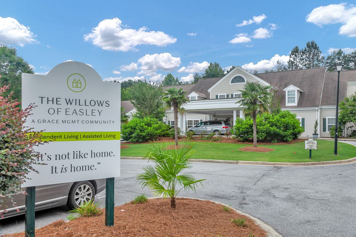 The front entrance of Willows of Easley, an assisted living community, featuring well-maintained landscaping and signage.