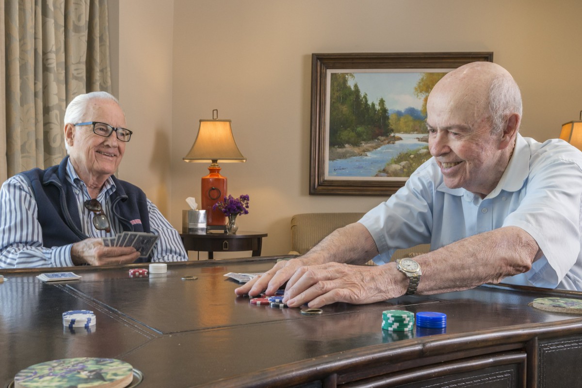 Two elderly men enjoying a game of cards together.