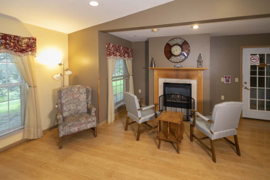 Cozy living room with a fireplace, seating area, and wooden flooring.