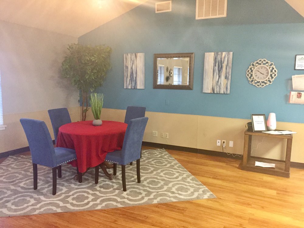 A cozy dining area with a red tablecloth, blue chairs, and various decorative elements.