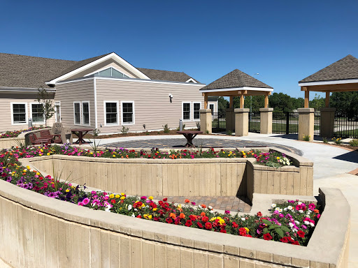 A beautifully landscaped area featuring a modern building and vibrant flower beds.