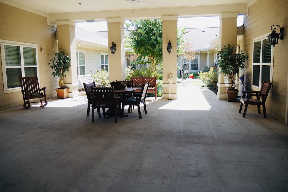 A tranquil patio with outdoor seating surrounded by plants.