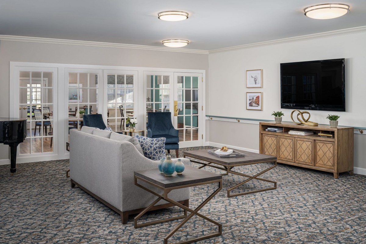A modern living room with stylish furniture and decor, featuring a sofa, coffee tables, and a television.