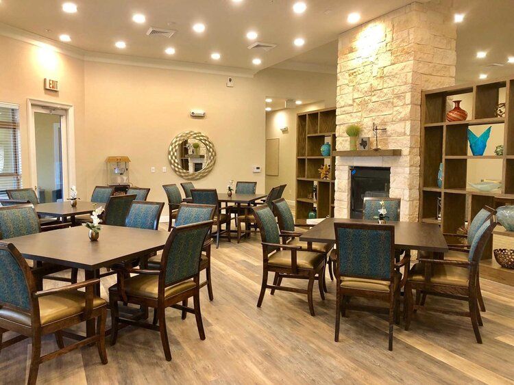 A modern dining area featuring multiple tables and chairs, a fireplace, and warm lighting.