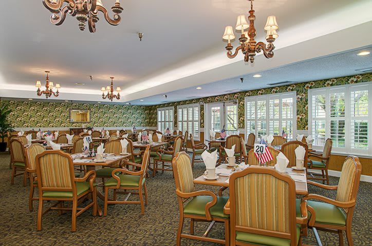 A classic and elegant dining room with ornate chandeliers and neatly arranged tables.