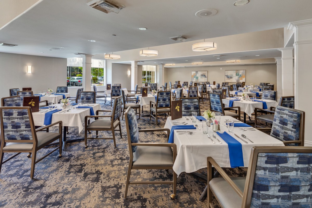 Elegant dining room set up with neatly arranged tables and chairs.