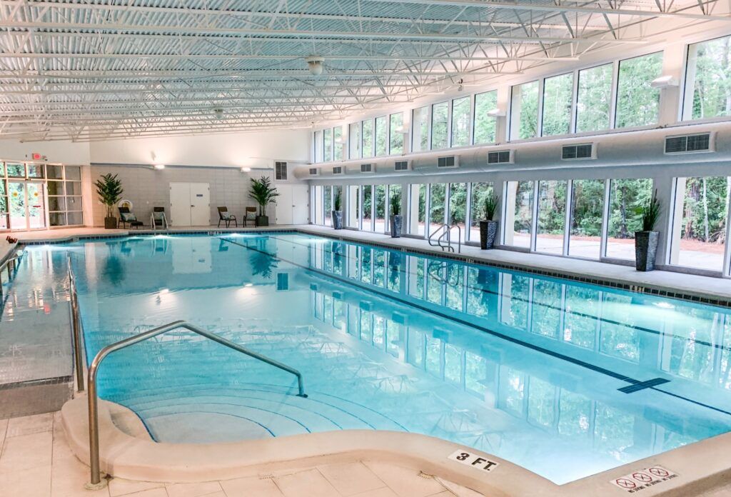 Spacious indoor swimming pool with large windows and natural lighting.