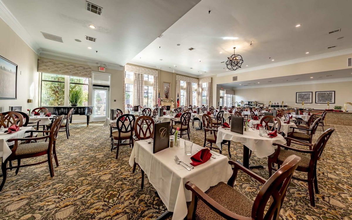 An elegantly set dining area in a restaurant with neatly arranged tables and chairs.