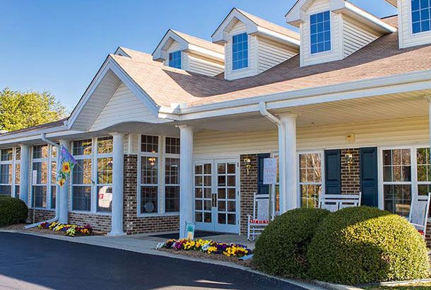 A suburban house with a porch and multiple windows.