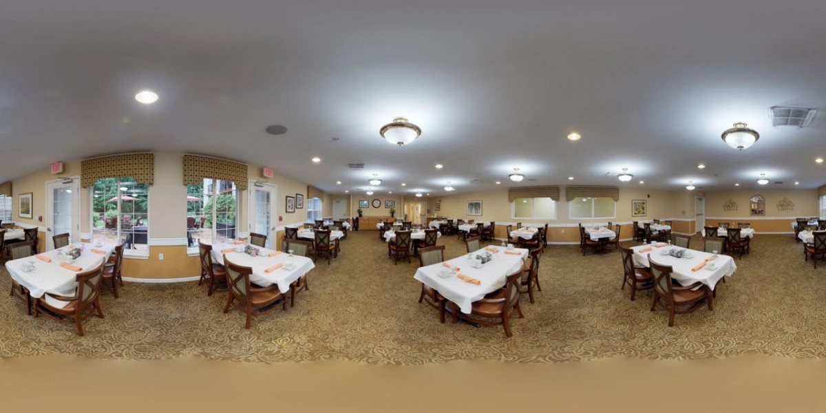 A spacious dining room with tables set with white tablecloths, ready for guests.
