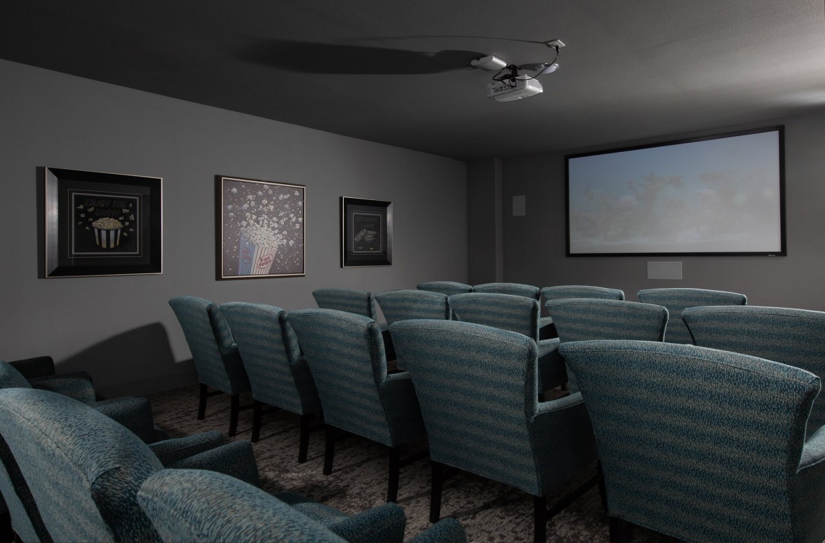 A cozy home theater setup with comfortable seating and a projector screen.