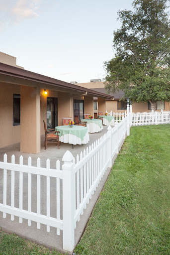 A charming outdoor view of a residential area featuring a white picket fence and cozy patios.
