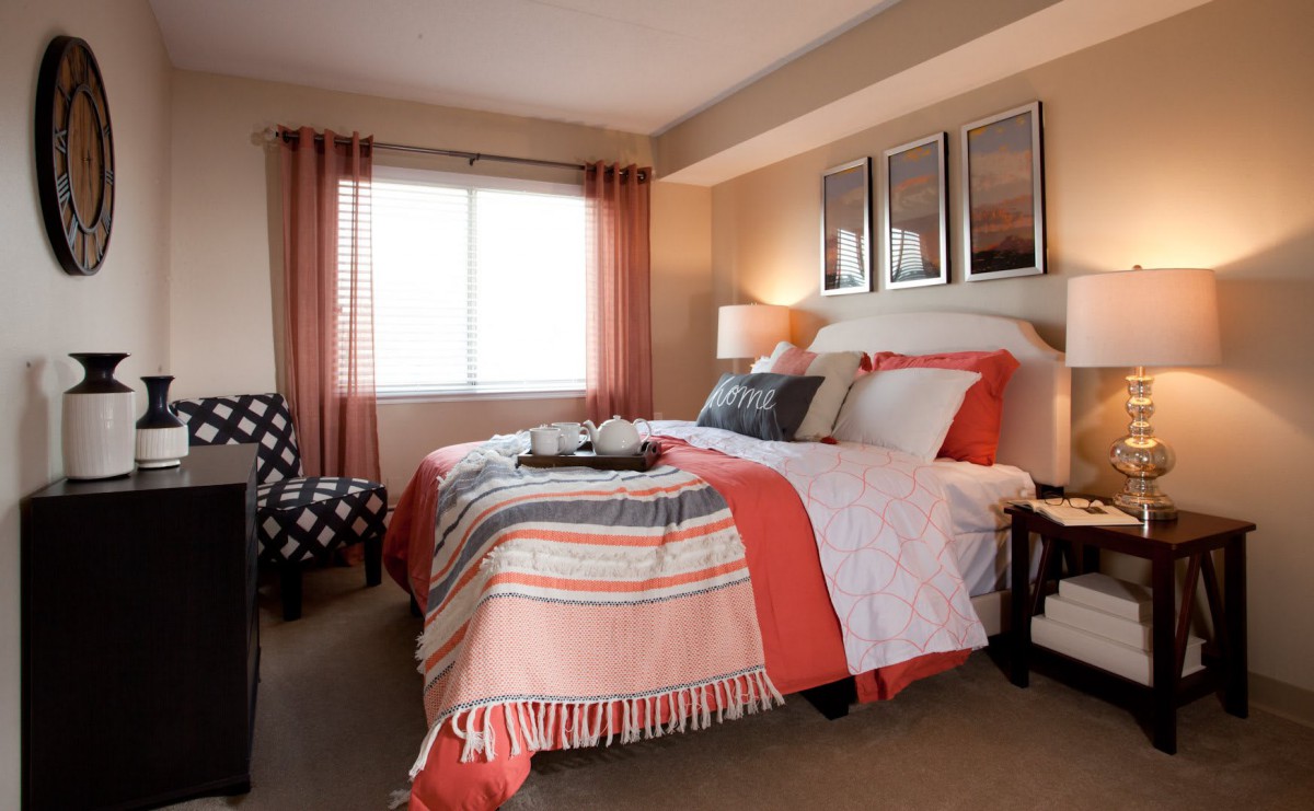 A cozy, modern bedroom with colorful bedding and elegant decor.