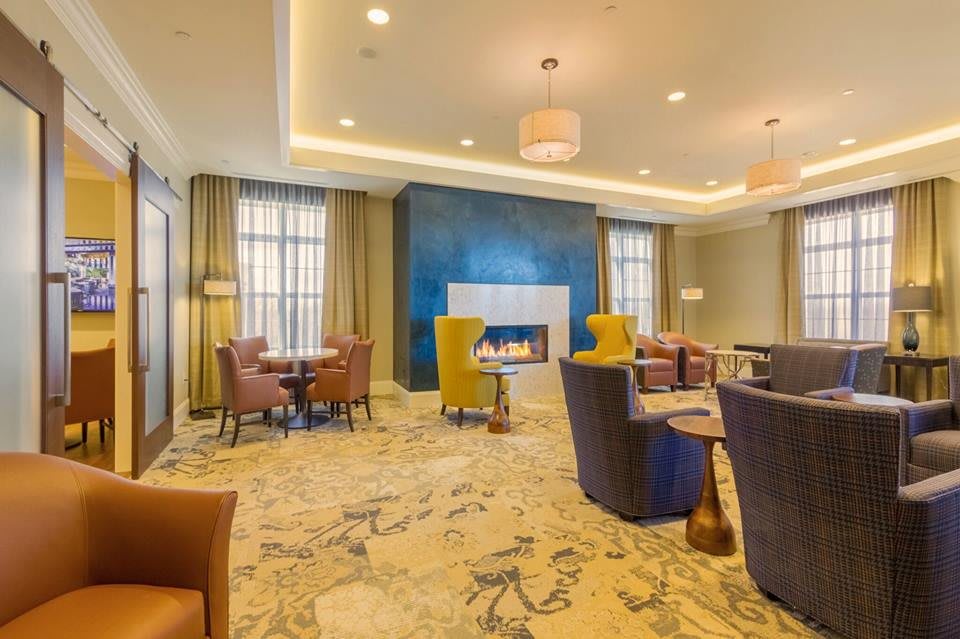 A modern lobby with a cozy seating area and fireplace.
