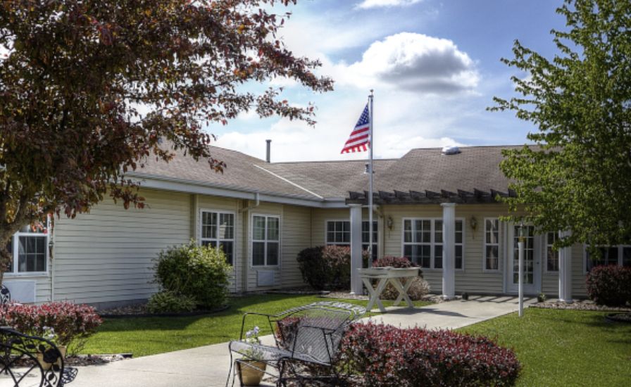 A residential house with a well-maintained yard and an American flag flying in front.