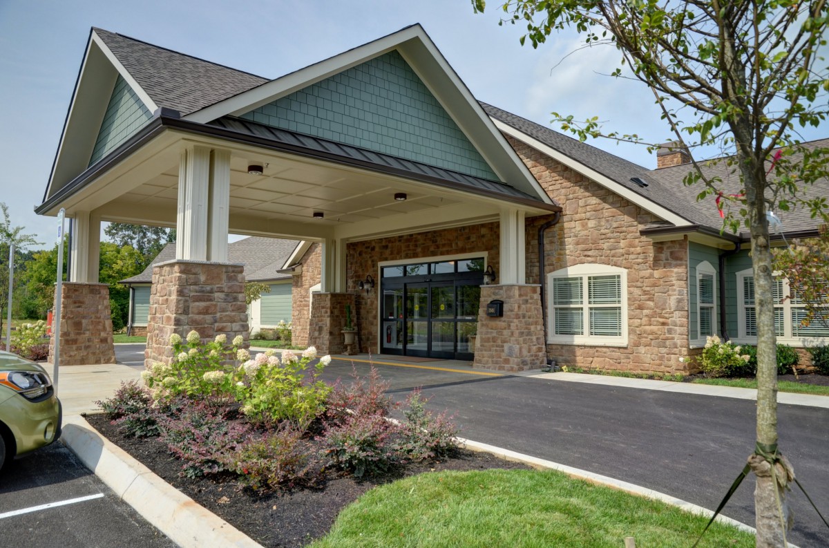 A modern residential building entrance with landscaped surroundings.