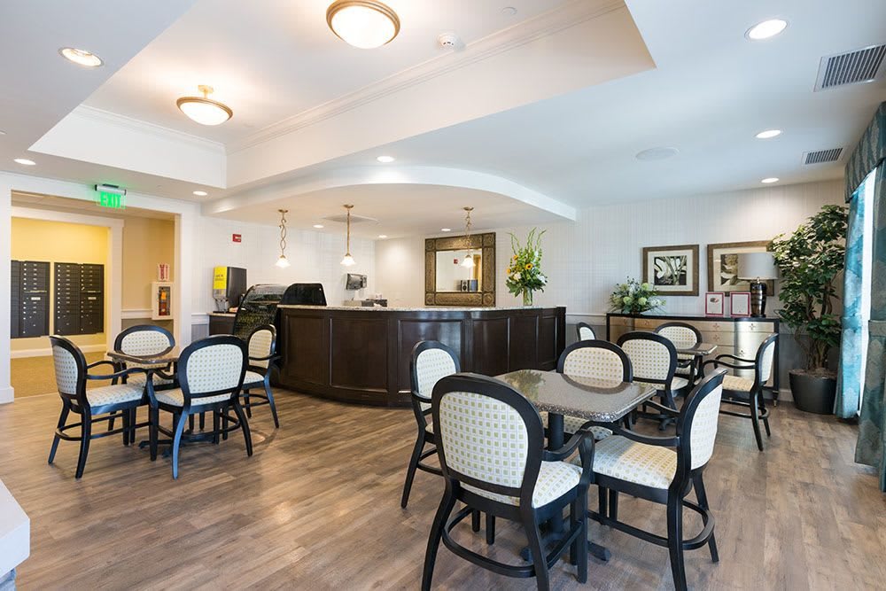 A reception and waiting area with tables, chairs, and elegant interior design.