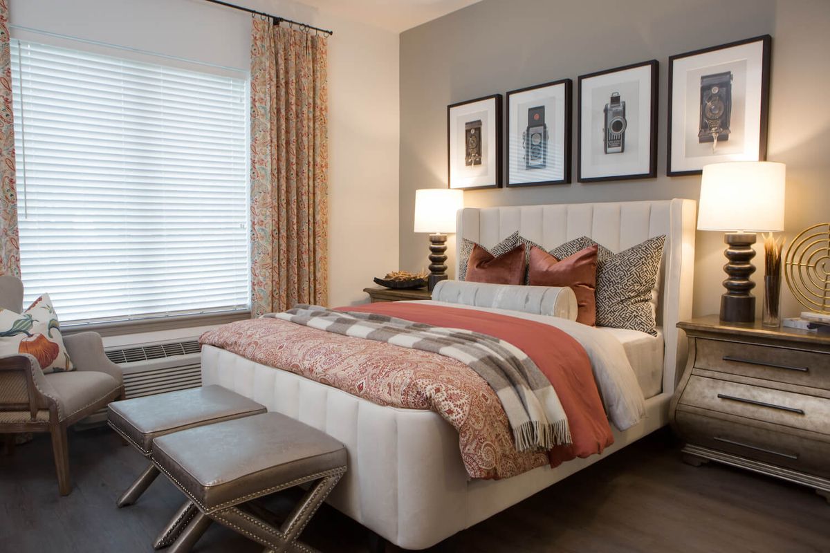 A modern and cozy bedroom with stylish decor and artwork above the bed.