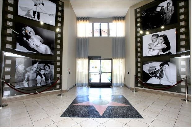 A cinema lobby with large film posters on the walls and a star design on the floor.