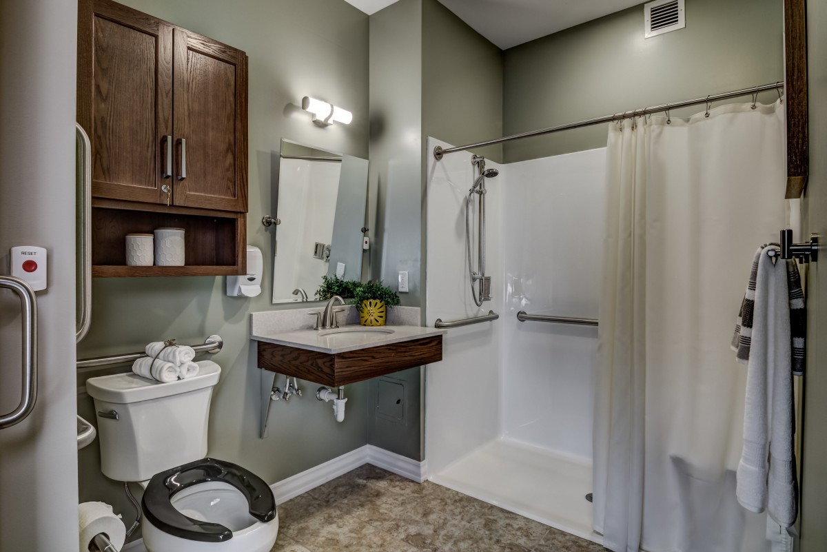 A modern bathroom with accessible features, including a walk-in shower and grab bars.