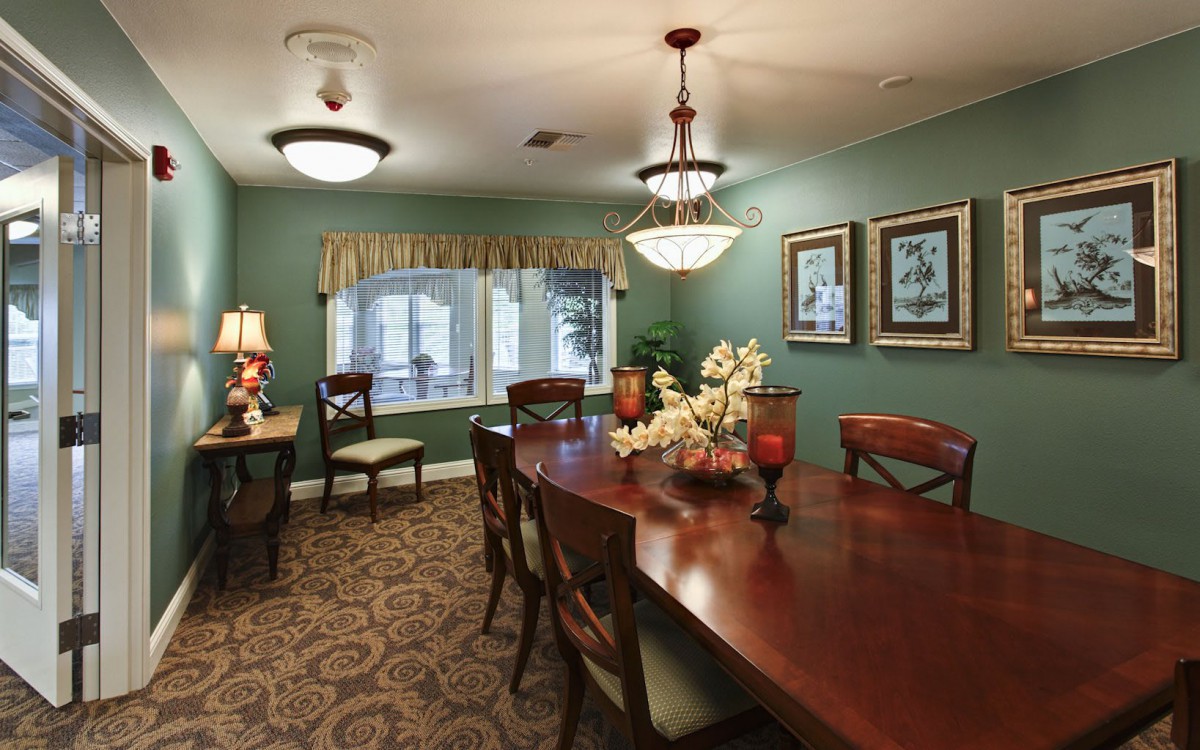 An elegantly designed dining room with a large wooden table, chandelier, and decorative items.