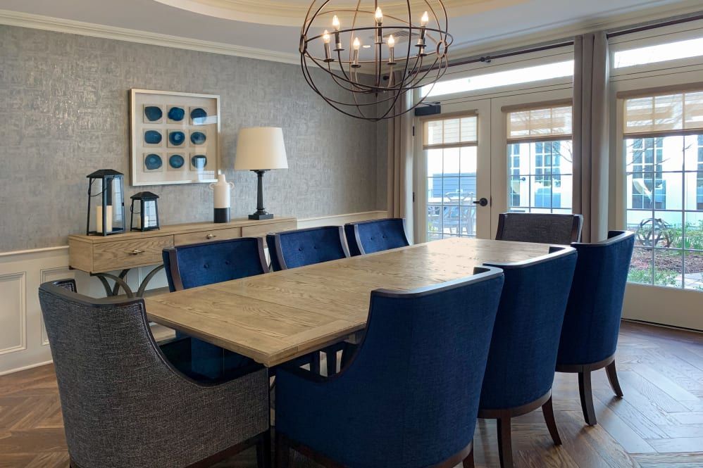 Modern dining room with a wooden table and blue upholstered chairs.