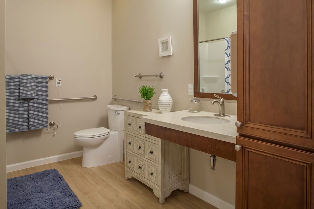 A well-designed bathroom with a toilet, sink, and mirror.