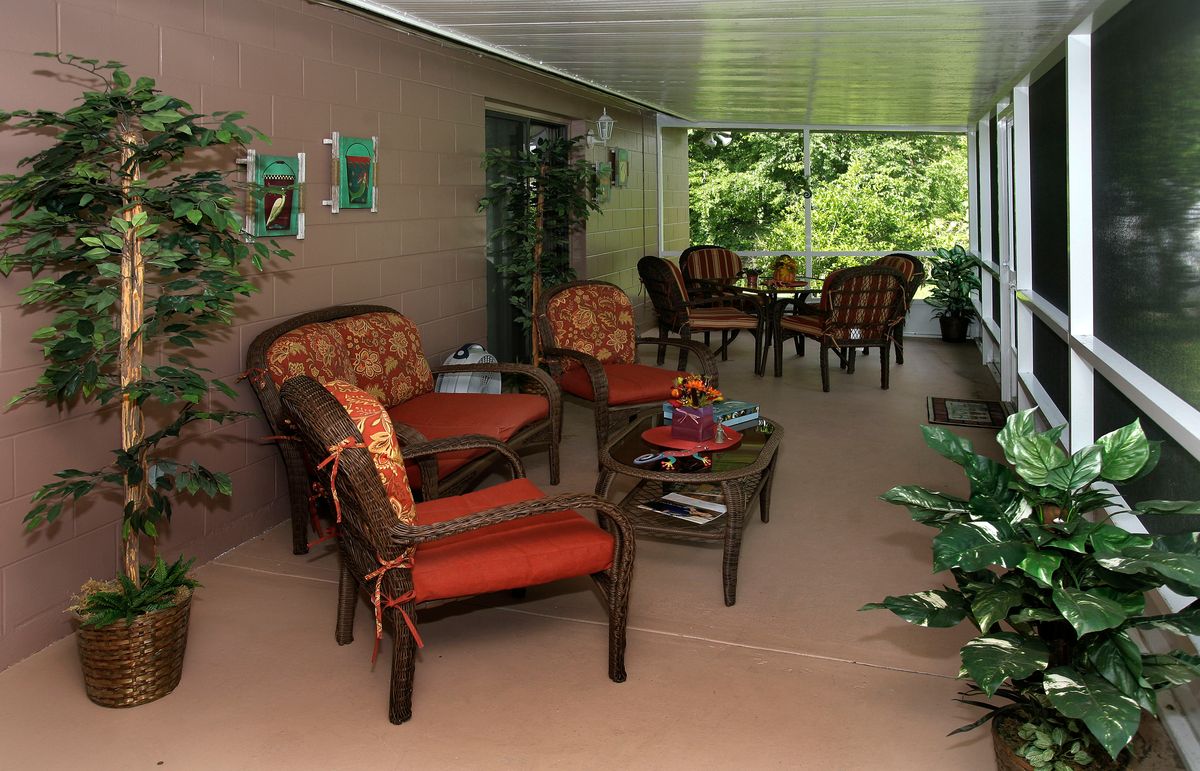 A cozy outdoor patio with comfortable seating and lush garden views.