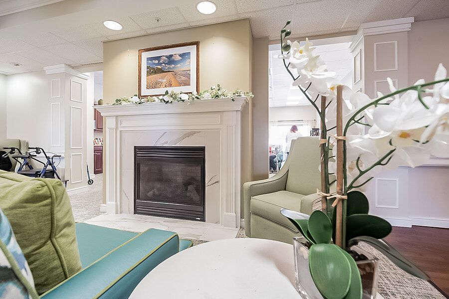 A cozy living room featuring a fireplace, armchair, and elegant decor.