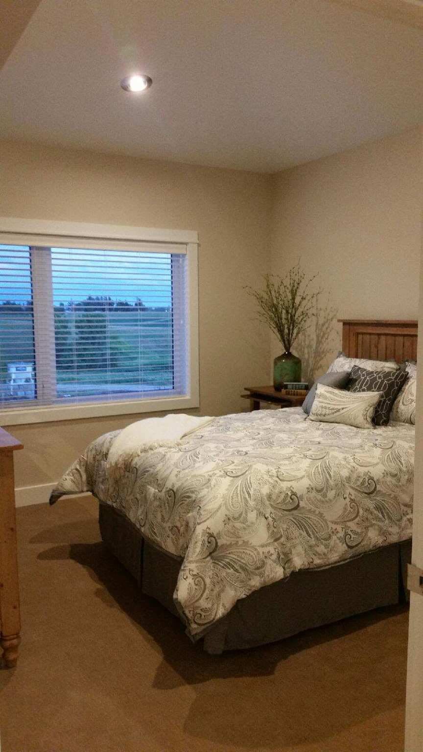 A cozy bedroom with a neatly made bed and a window view.