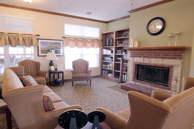A cozy living room with a fireplace, bookshelves, and comfortable seating.