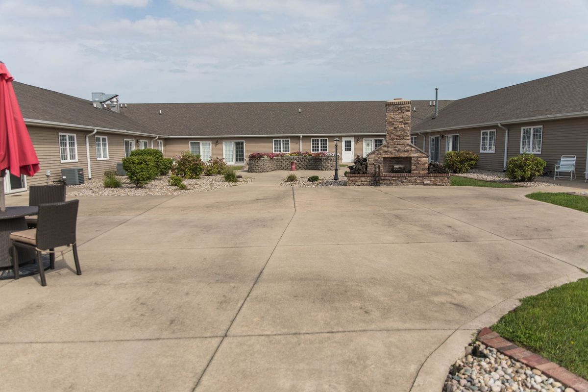 A view of a motel courtyard with surrounding buildings and a central fireplace.