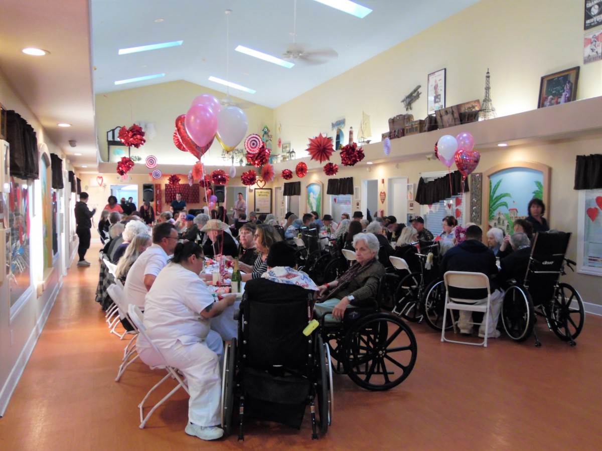A lively indoor celebration with people, festive decorations, and balloons.