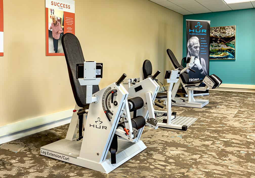 A fitness center featuring specialized exercise machines lined up for use.