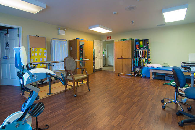 A rehabilitation room equipped with exercise equipment for physical therapy.