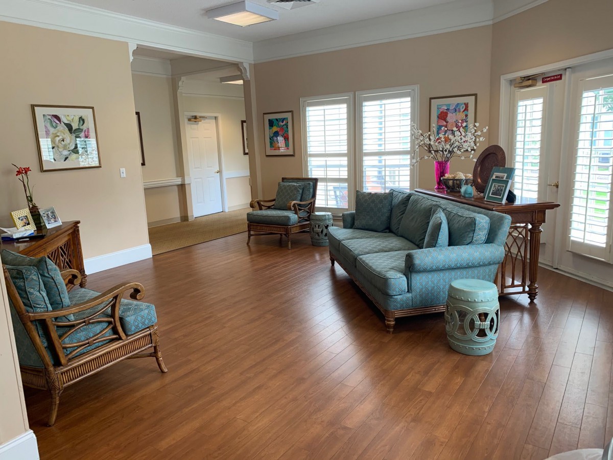 A cozy living room with a sofa, chairs, and artwork on the walls.