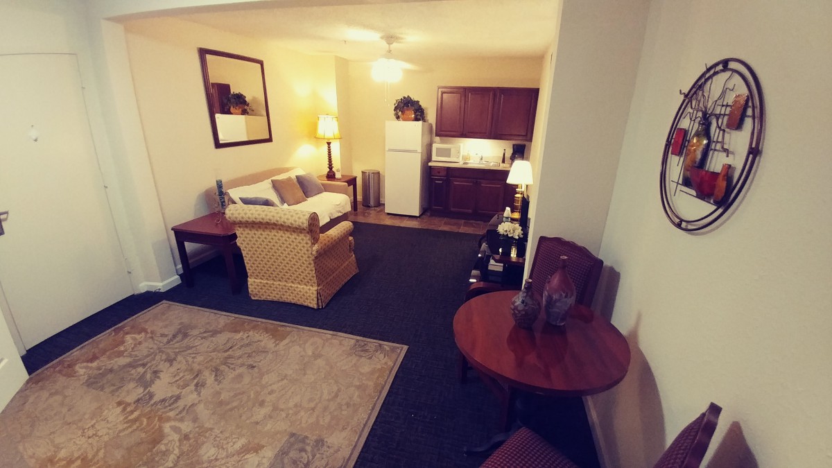 A cozy living area with a sofa, table, and kitchenette.