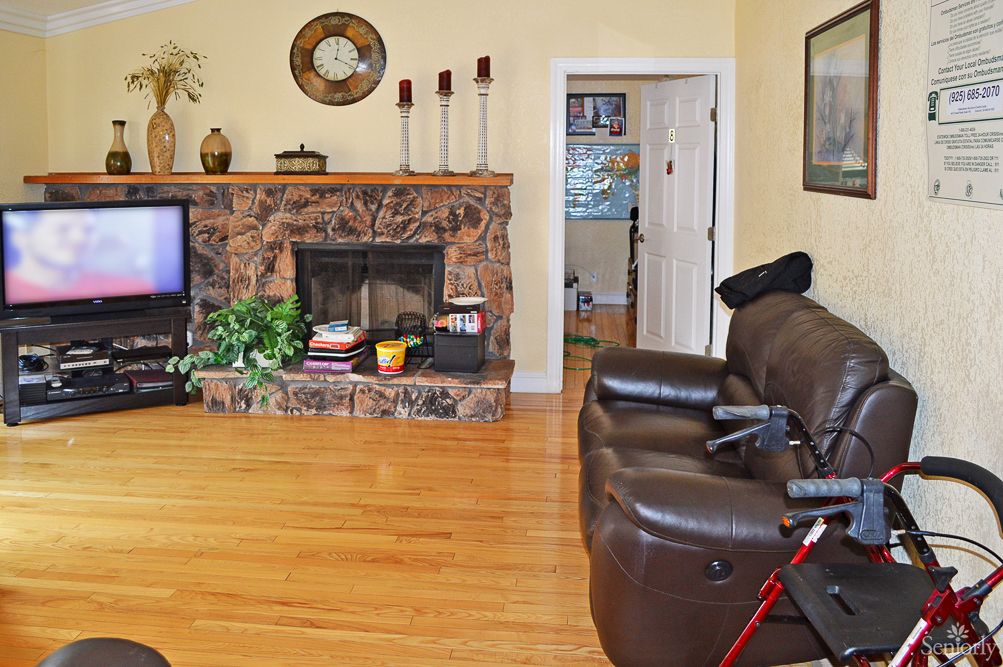 A cozy living room with a fireplace, TV, and accessible seating.