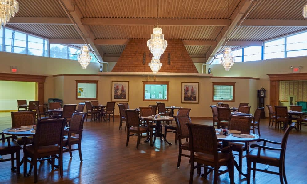 A spacious restaurant interior with elegant chandeliers and wooden decor.