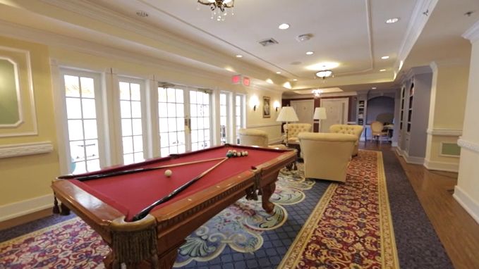 A cozy recreation room featuring a red pool table and comfortable seating.