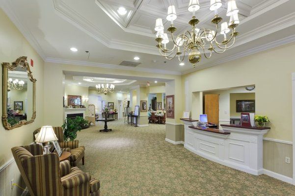A well-lit reception area with elegant chandeliers and comfortable seating.
