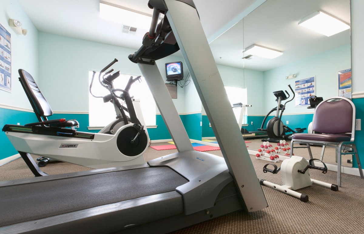 A fitness center with treadmills and elliptical machines.