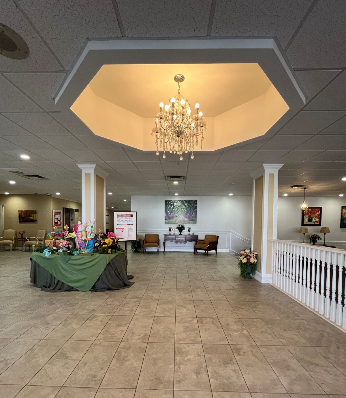 A spacious lobby with a chandelier, seating area, and decorative elements.