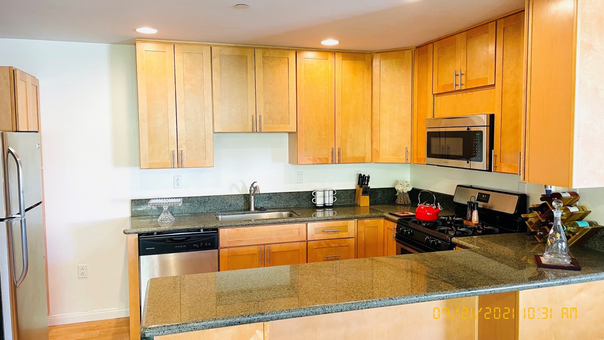 A modern kitchen with wooden cabinets and a granite countertop.